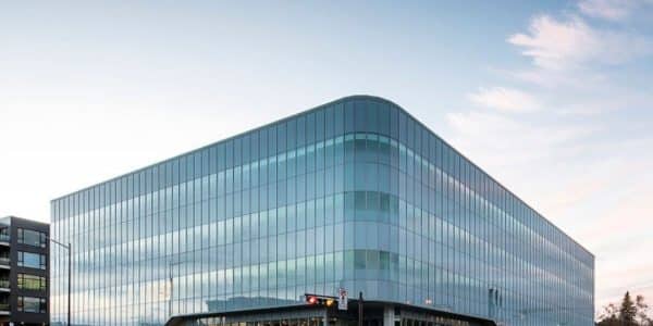 Un immeuble de bureaux moderne en verre sur une rue de ville.