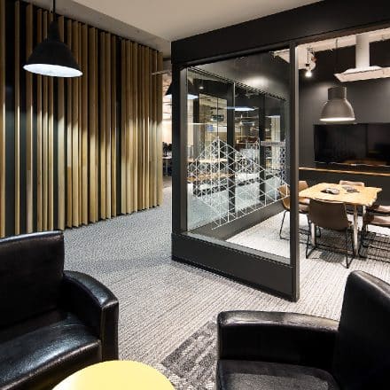 Un intérieur de bureau moderne avec une salle de réunion vitrée et un espace salon.