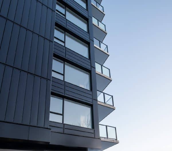 Un immeuble moderne avec un extérieur sombre et des balcons.