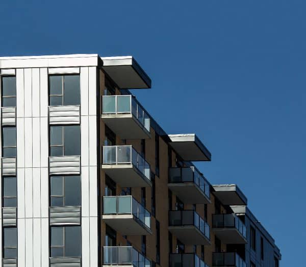 Un immeuble d'appartements moderne avec balcons sur fond de ciel bleu.