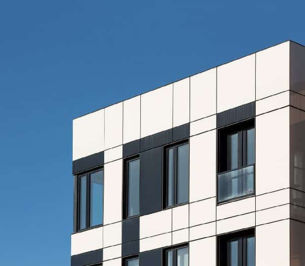 Un bâtiment moderne avec une façade en damier noir et blanc et plusieurs fenêtres.