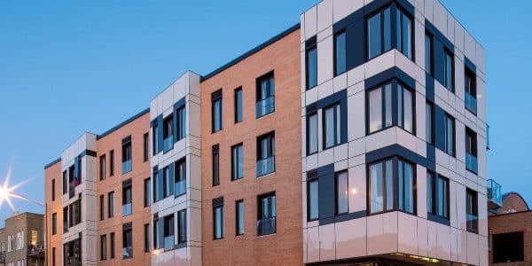 Un immeuble moderne en brique avec un Starbucks au rez-de-chaussée.