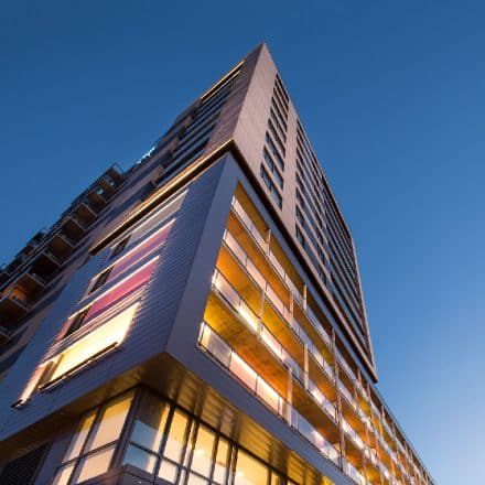 Vue en contre-plongée d'un immeuble d'appartements moderne au crépuscule.