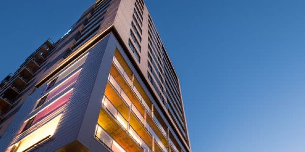 Vue en contre-plongée d'un immeuble d'appartements moderne au crépuscule.