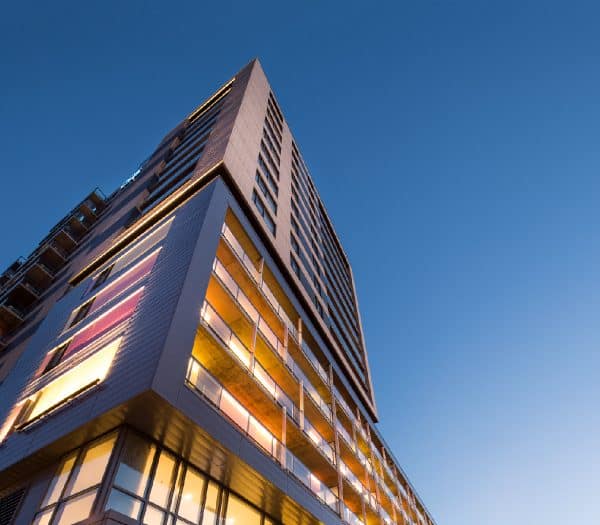 Vue en contre-plongée d'un immeuble d'appartements moderne au crépuscule.